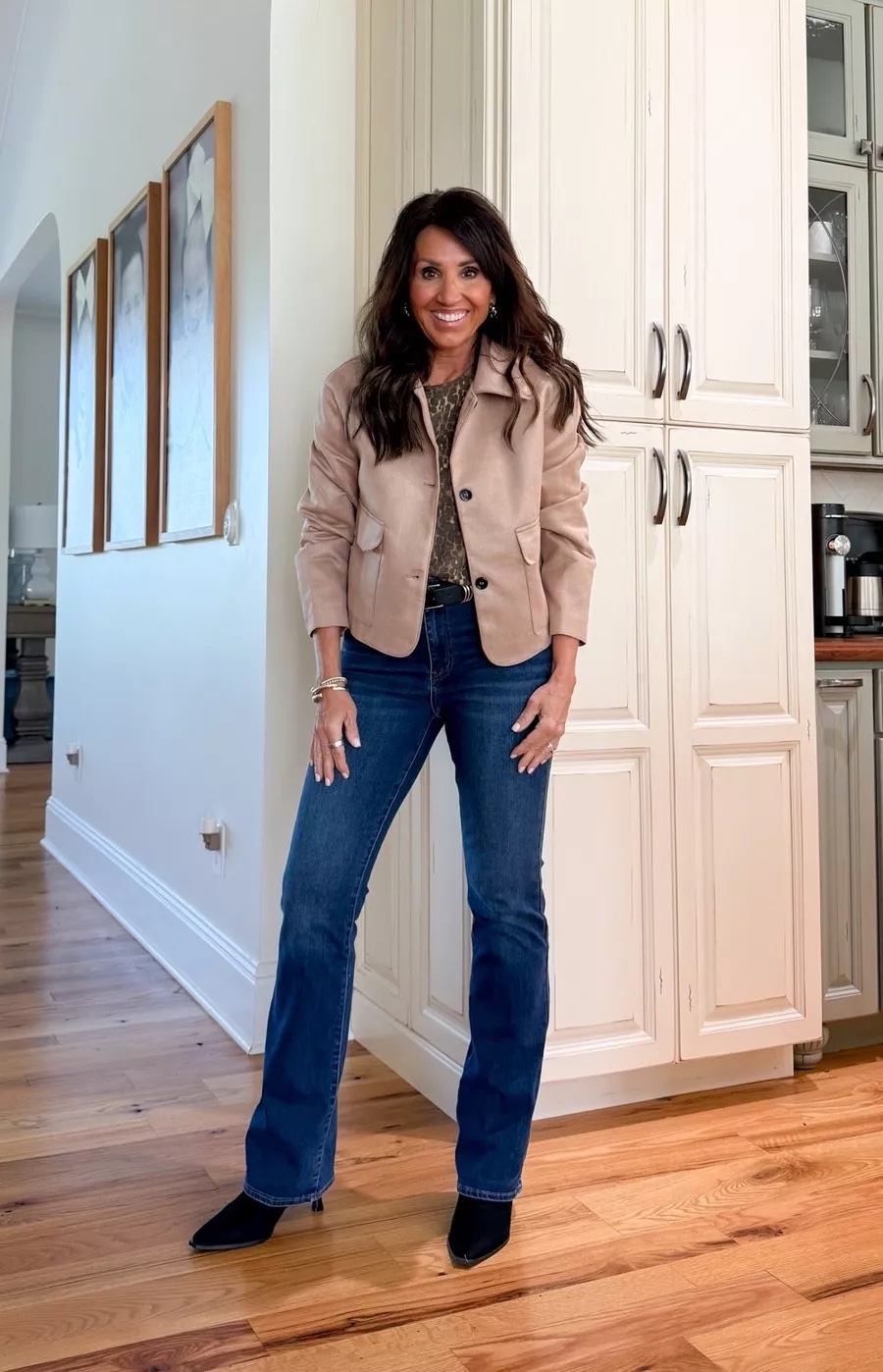 Cyndi Spivey wearing a neutral cropped jacket with dark wash bootcut jeans and black pointed-toe boots for a polished fall outfit.