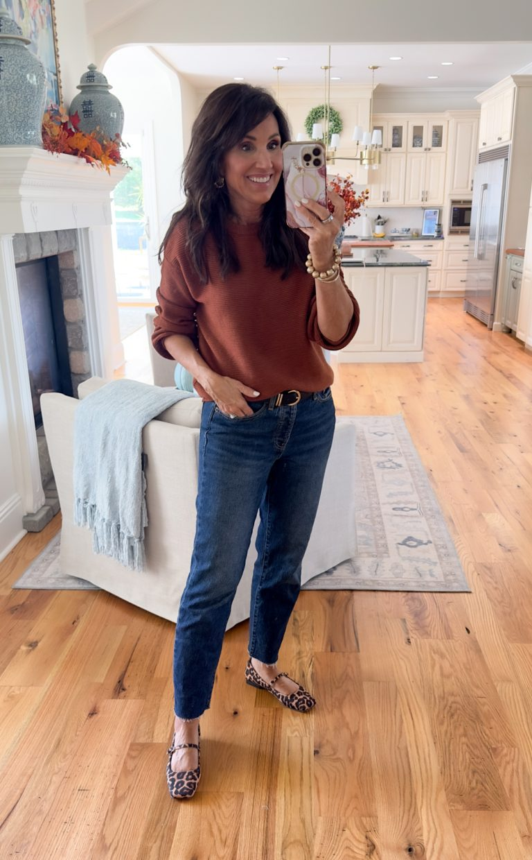 WOMAN STYLING A RUST ORANGE BROWN SWEATER FOR FALL WITH LEOPARD PRINT BALLET FLATS AND JEANS