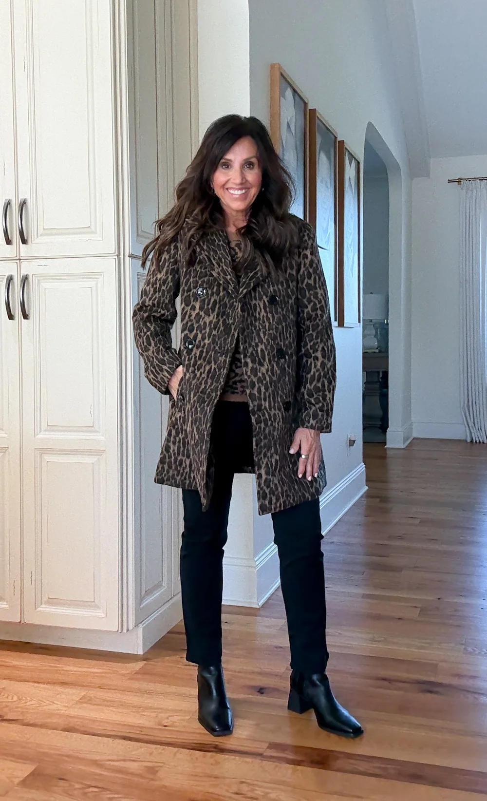 Cyndi Spivey wearing a leopard print coat with black jeans and boots, a bold and stylish winter outfit.