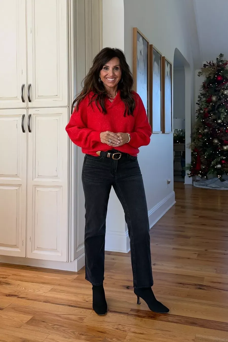 A cozy red sweater paired with black jeans and booties—an effortless and festive holiday outfit for casual gatherings.
