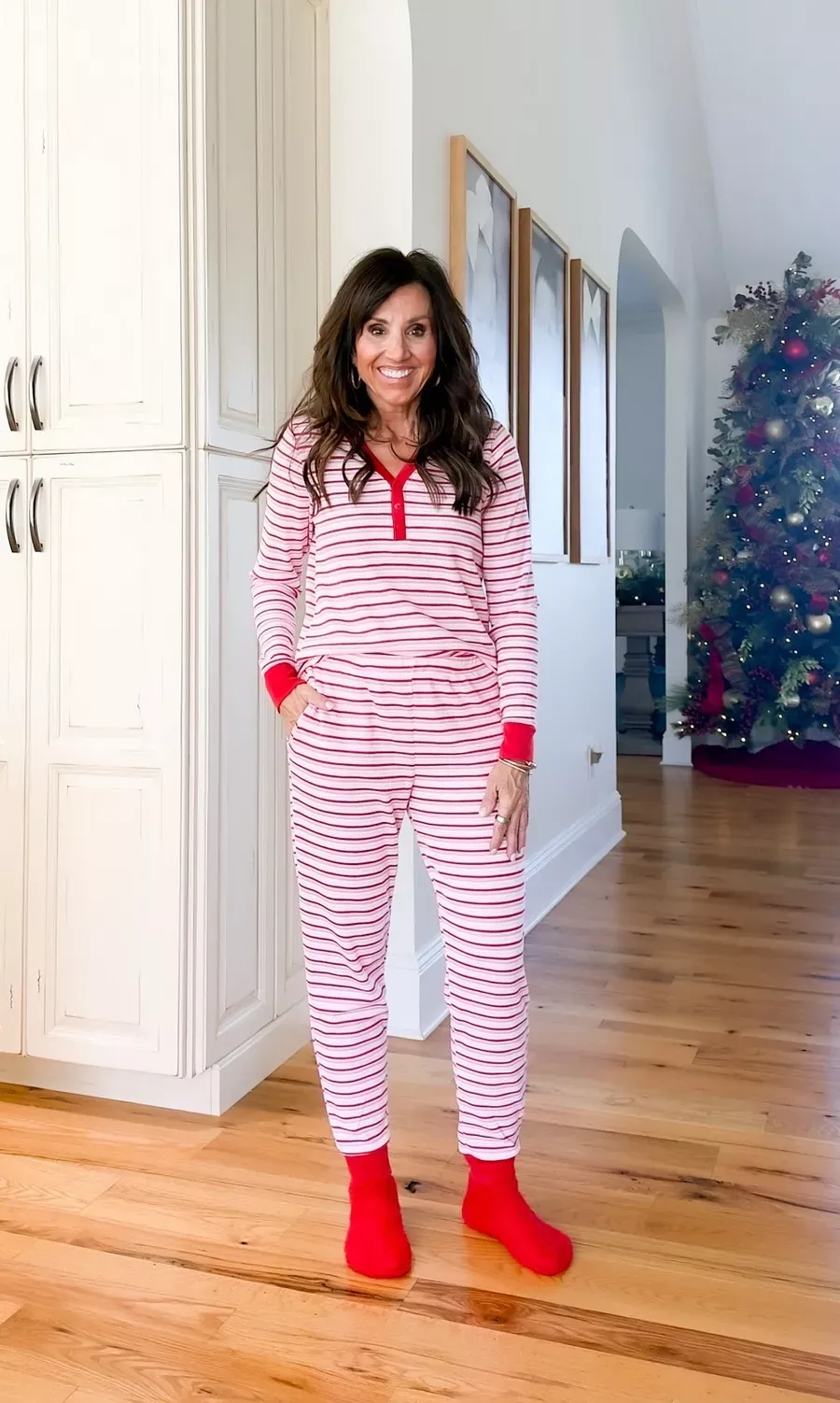 CYNDI SPIVEY WEARING RED AND PINK STRIPED CHRISTMAS HOLIDAY PAJAMAS THAT ARE PREFECT FOR LOUNGING AT HOME 