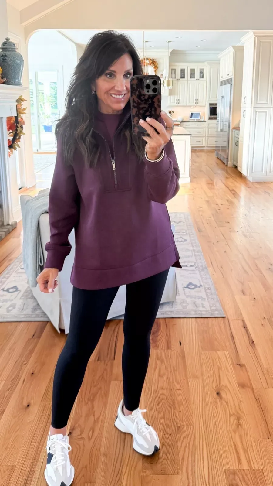 CYNDI IS WEARING A PLUM BURGUNDY QUARTER ZIP PULLOVER WITH LEGGINGS AND SNEAKERS FOR A COMFORTABLE CASUAL HOLIDAY LOOK