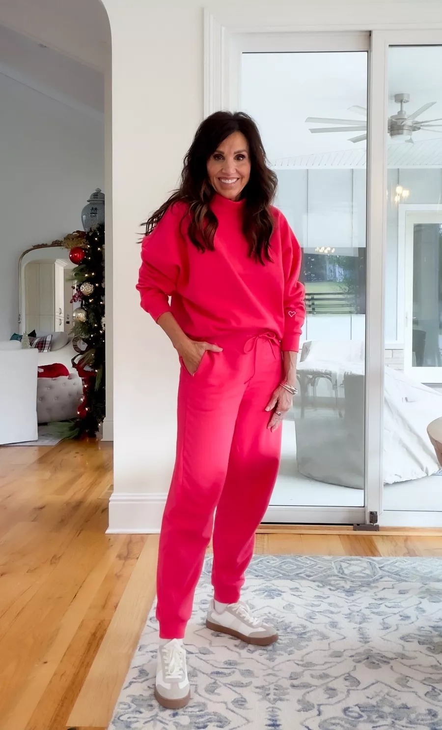 Cyndi Spivey wearing a colorful outfit made of bright red matching sweatshirt and jogger set with white and taupe sneakers.