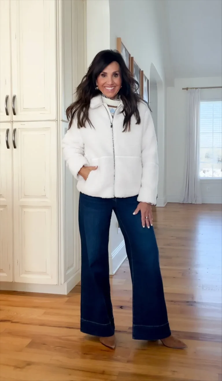 Cyndi wearing a jacket with wide leg jeans. 