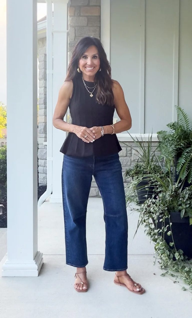 Dark wash cropped jeans styled with a black sleeveless top and flat sandals